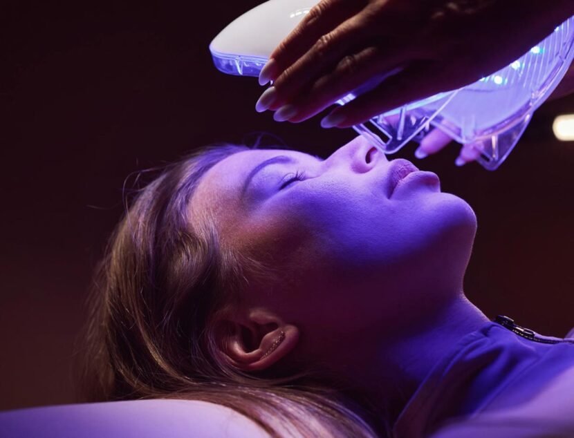 Advances in Eczema Treatment and Symptom Management A person is receiving a facial treatment under a blue light therapy device.